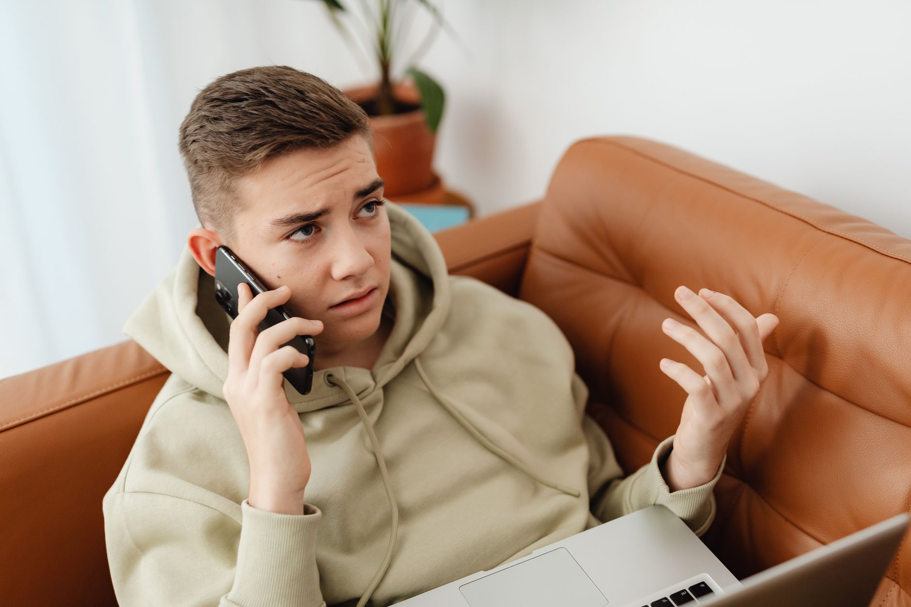 Person looking at smartphone with a worried expression while sitting at a desk