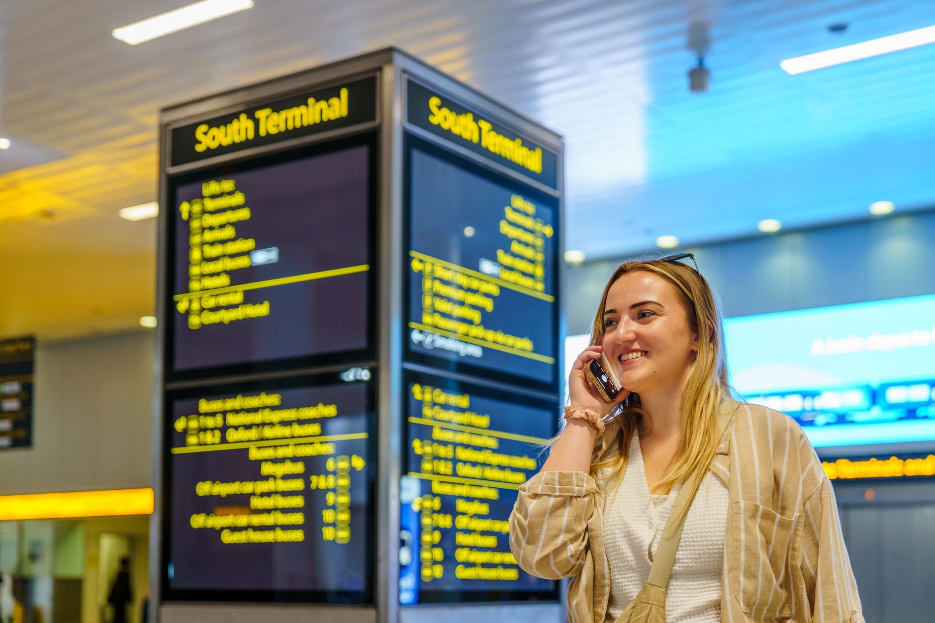 Woman using a smartphone while sitting in an airport lounge.