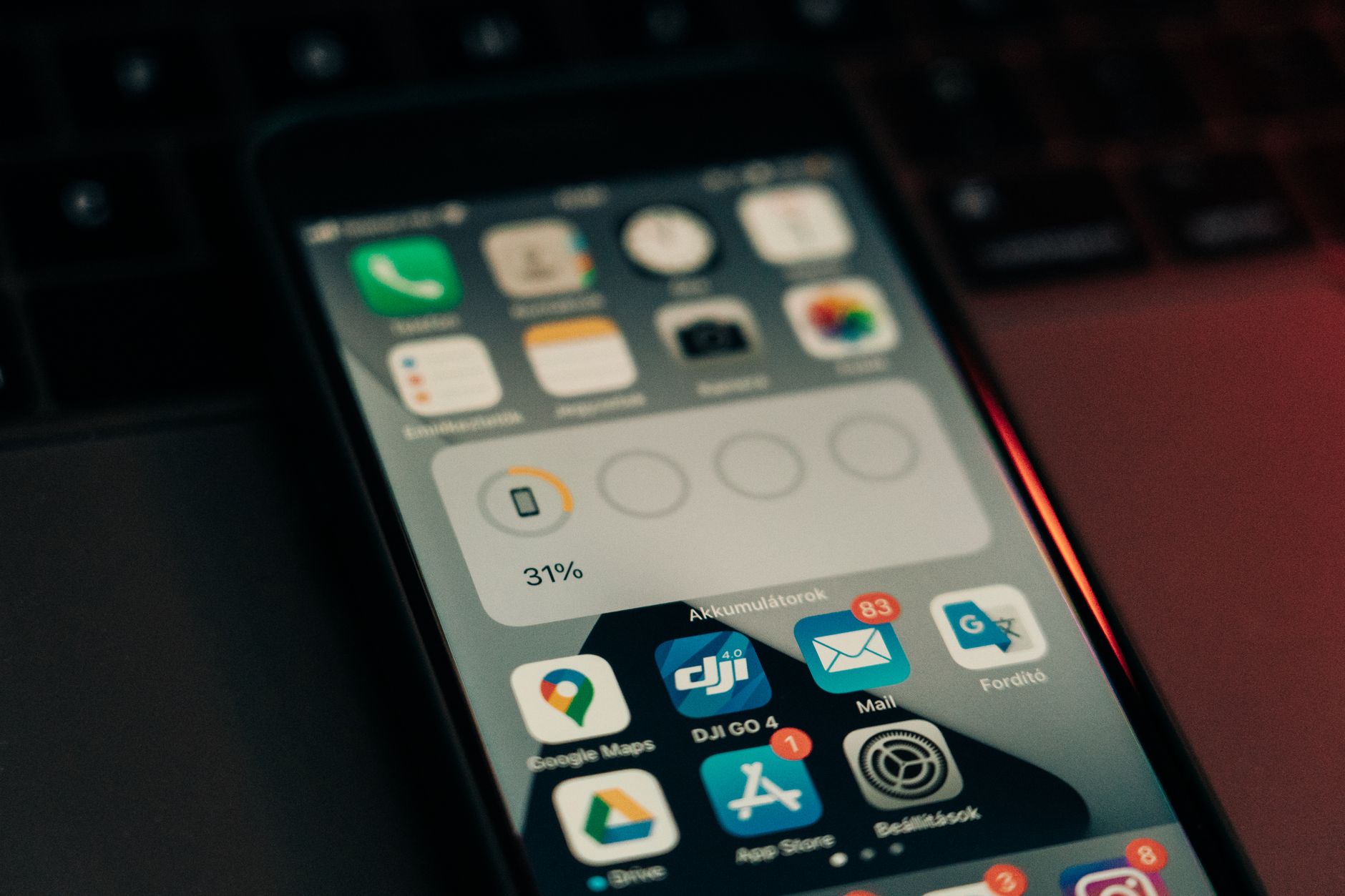 A hand holds a smartphone showing a map with location pins and app alerts.