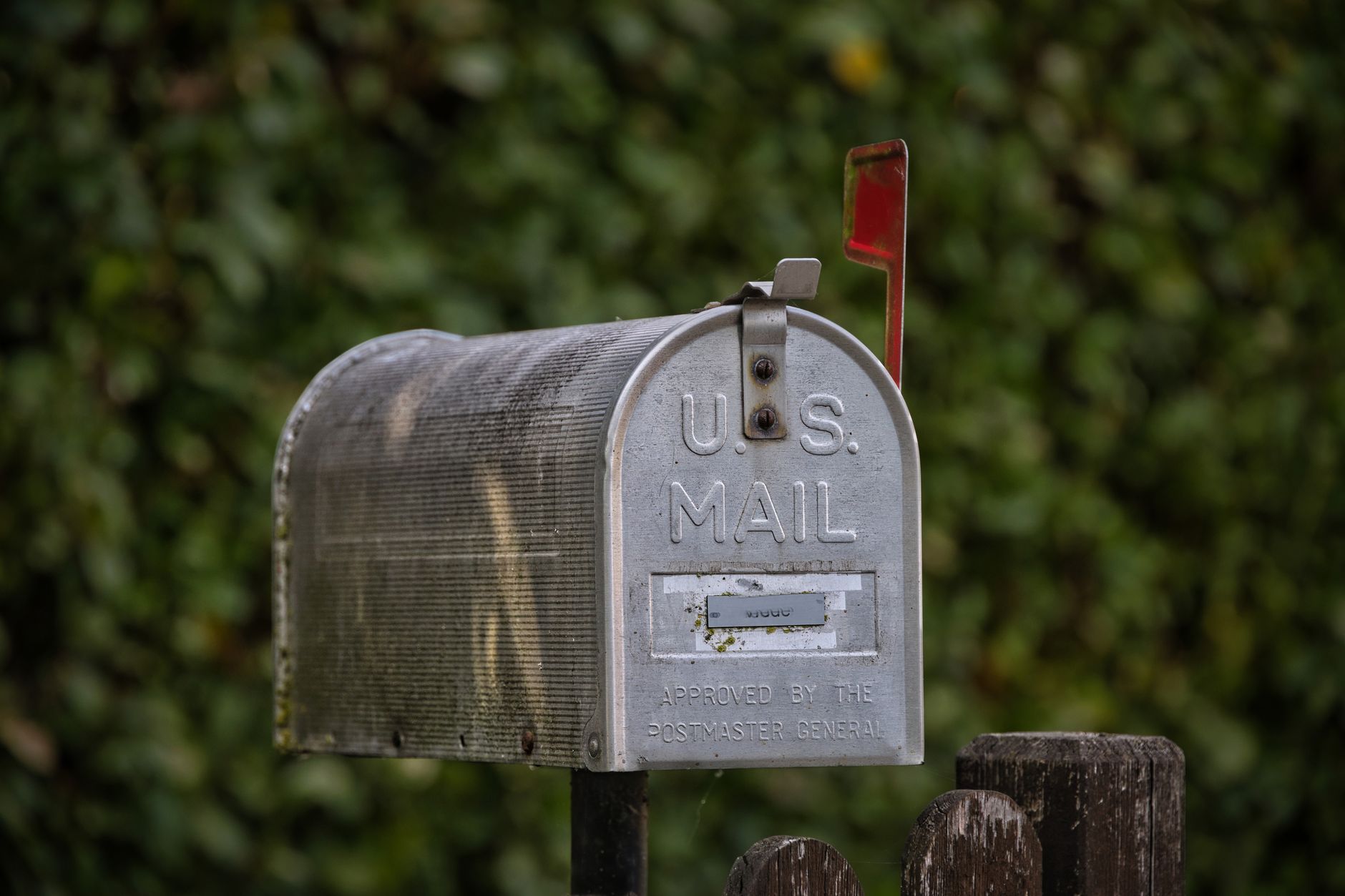 An overflowing home mailbox stuffed with spam letters and flyers.