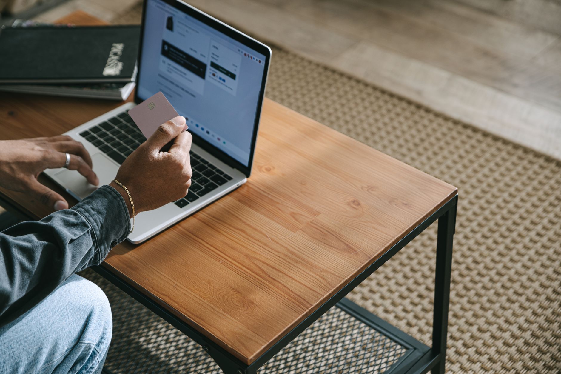 Person placing a credit freeze online on a laptop at a home desk with a credit card nearby.