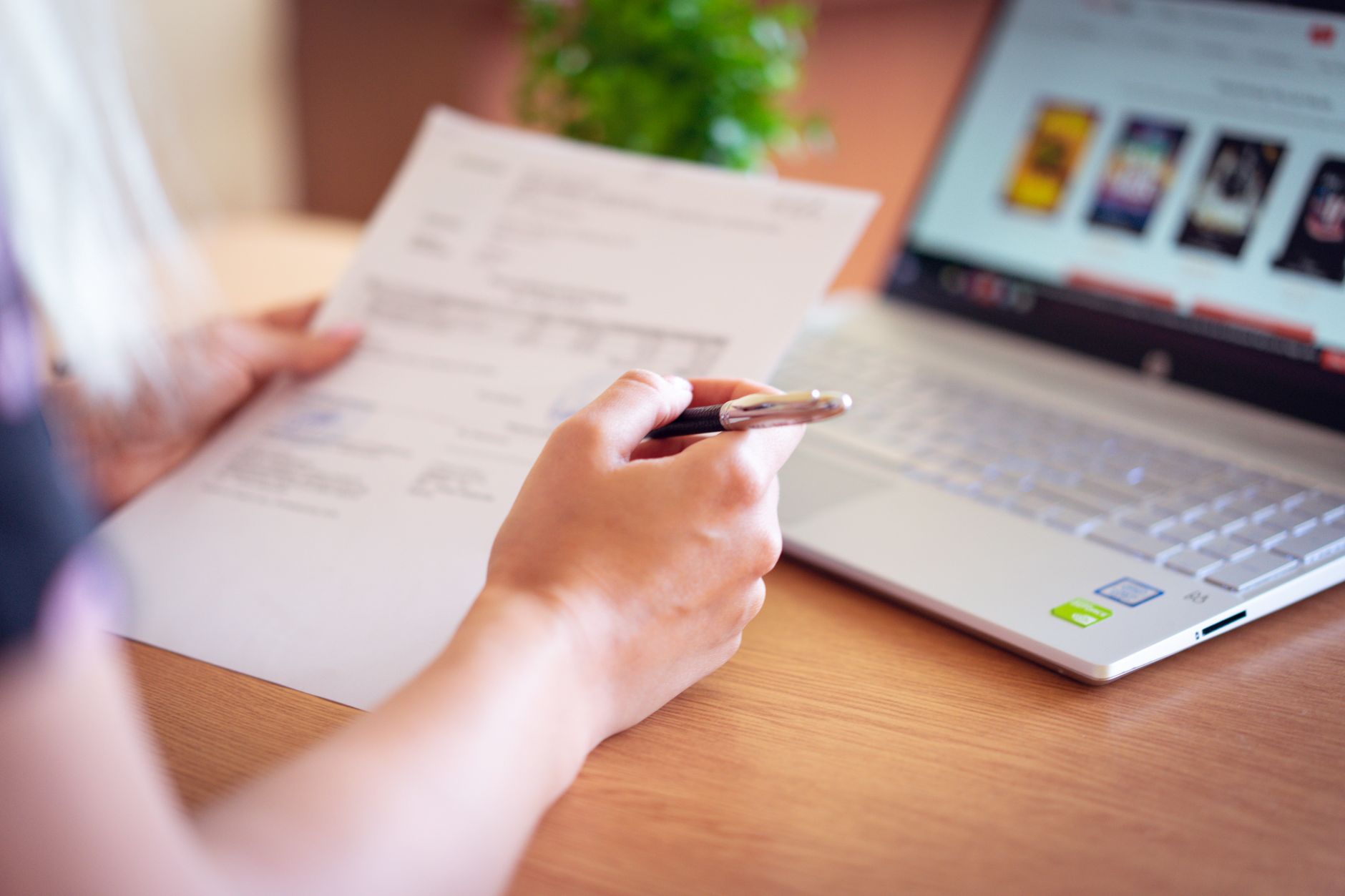 Adult reviewing loan paperwork at a desk with a laptop before lifting a credit freeze.