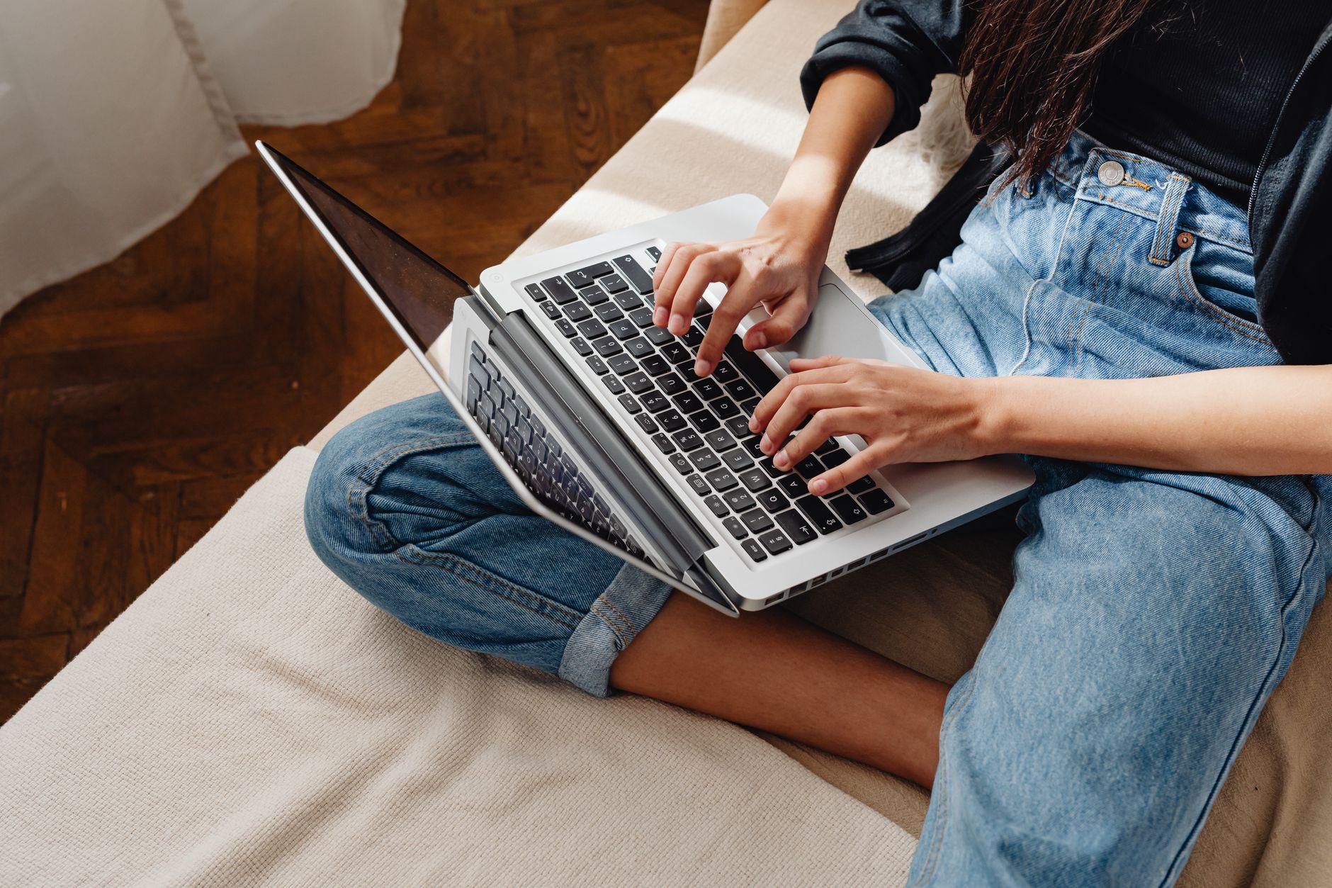 Person typing on a laptop while viewing a data privacy website, removing personal information from an online directory.